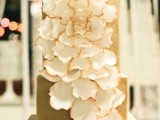 a square matte gold wedding cake decorated with white sugar blooms is a stylish and elegant modern idea