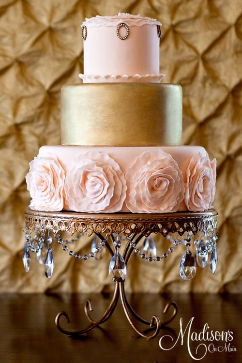 a sophisticated wedding cake with blush pink and gold tiers, with sugar blooms and embellishments for a refined wedding