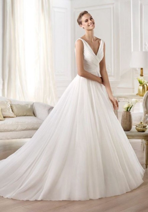 a plain wedding ballgown with a V-neckline, no sleeves, a draped bodice and a pleated full skirt with a train just wows with its elegance