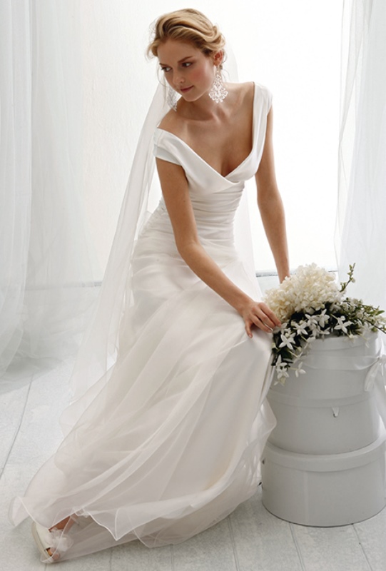 A refined and timeless plain A line wedding dress with cap sleeves, a deep V neckline, with a veil gives an abslutely timeless bridal look