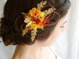 a wedding updo on medium hair, with a low bun and a large double braid on one side, with a bold floral hair accent