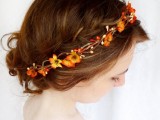 an updo on medium hair, with a braided halo and a faux bright flower crown is a pretty idea for a relaxed fall bride