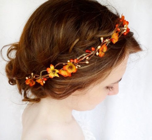 an updo on medium hair, with a braided halo and a faux bright flower crown is a pretty idea for a relaxed fall bride