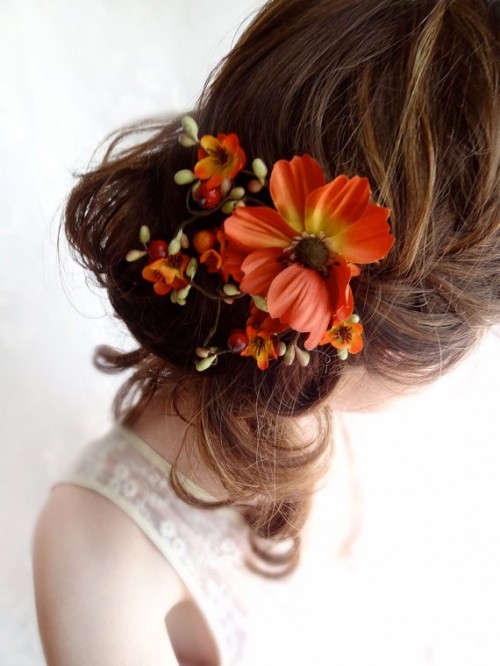 a messy half updo with a braid and curls down with bold faux fall blooms to make the look more eye-catchy and fall-inspired