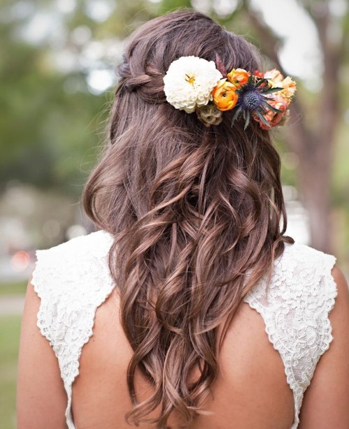 a pretty half updo with a braided halo and waves down plus fresh orange, white blooms, a seed pod and a thistle piece is a lovely idea for the fall