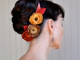 a wedding updo with a large braid wrapped and a bold faux bloom headpiece to make an accent