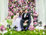a chic floral wall in pink, white and green plus light fabric on both sides as a wedding and lounge backdrop