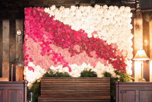 a bright floral wall in white, fuchsia and light pink blooms designed with a color block effect