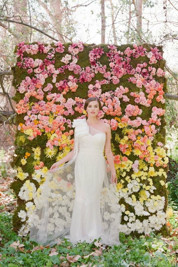 An ombre floral wedding backdrop from pink to yellow and white plus moss as a background