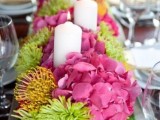a colorful spring wedding centerpiece in pink, yellow and green plus pillar candles in a box