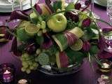 a deep purple and gree wedding centerpiece done with apples, grapes, limes for a dramatic spring wedding