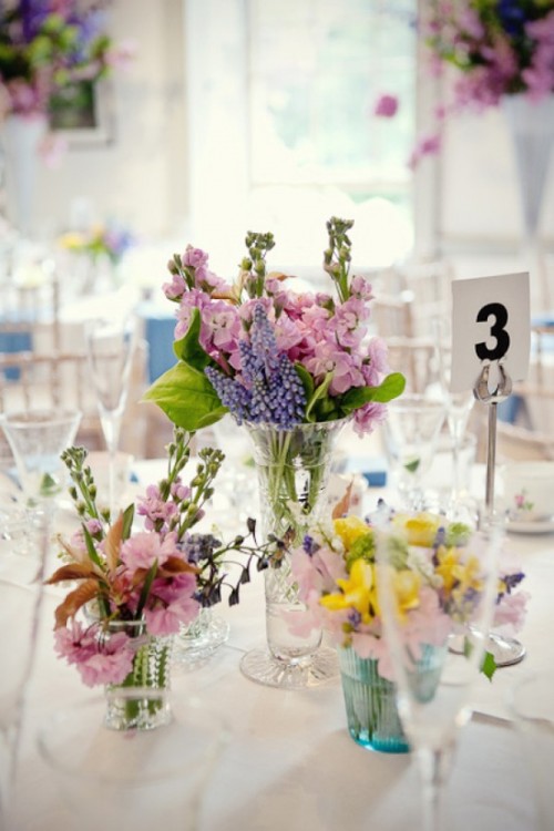 a pink, lilac and yellow floral wedding centerpiece with some foliage is a cool idea for spring or summer