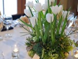 a refreshing spring wedding centerpiece of moss, grass and white tulips is all you need for a springy feel at the table
