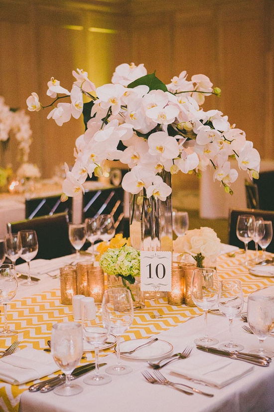 a tall pink orchid centerpiece in a clear vase is a chic and refined spring wedding ideas
