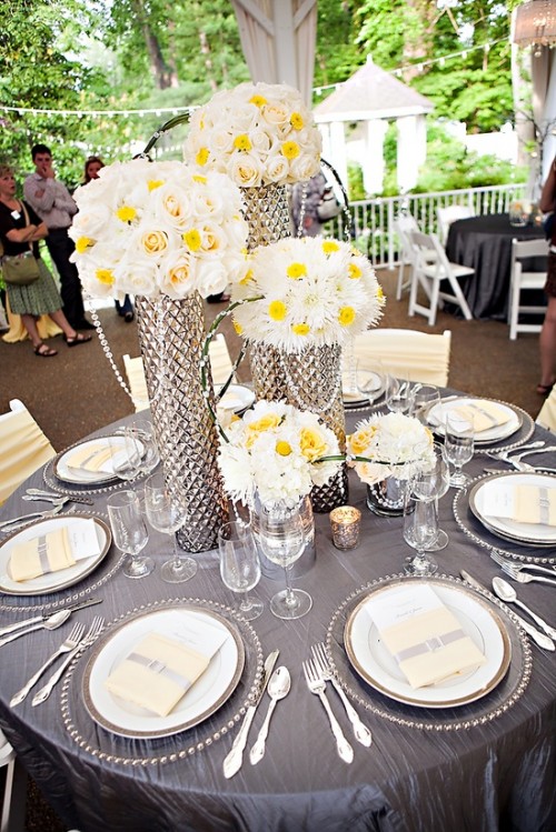 tall spring wedding centerpieces of white and yellow blooms in silver vases are cool spring wedding centerpieces