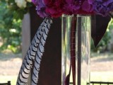a tall purple and pink floral centerpiece in a clear tall vase is great for a bright spring wedding