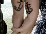 an anchor and an anchor with a bow on the wrists are romantic tattoos for a sea-loving couple