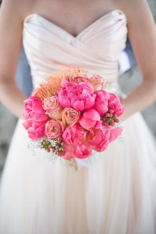 a bright wedding bouquet of ponies, roses and pincushion proteas and berries is a lovely and bold idea for summer