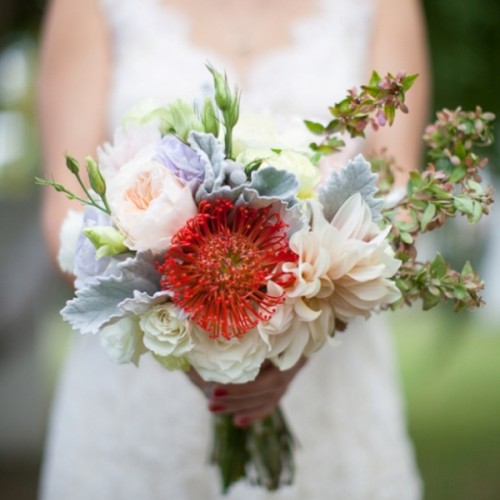 neutral peony roses, white roses, pincushion proteas, succulents and pale foliage are a bold combo for a wedding
