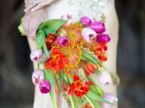 a bright wedding bouquet of lilac, red and purple tulips, pincushion proteas is a bold and a very quirky idea