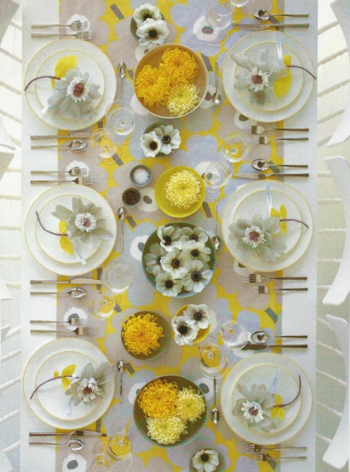 a fresh and bright spring wedding tablescape with white and yellow blooms, a bold runner and gold edge plates is all chic