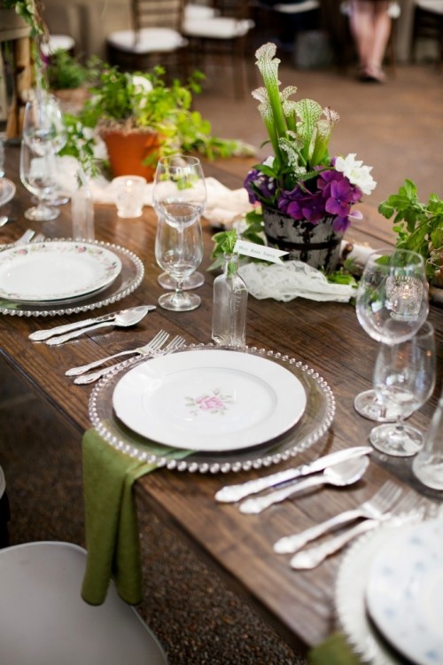 a bright spring wedding tablescape with a light and airy runner, neutral and bold blooms and greenery, green napkins, sheer chargers and floral plates