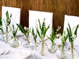 a vivacious spring wedding tablescape with lily of the valley in sheer vases, sheer plates and white linens is very fresh