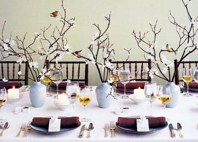 A fresh spring wedding tablescape with brown napkins, blooming branches, candles and cards feels like spring