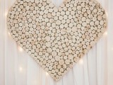 a large heart made of wooden slices is a cool and cozy rustic reception backdrop
