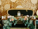 a gold sequin reception backdrop with hoops with newspapers is a fun and creative backdrop idea