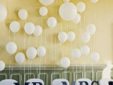 white balloons attached to the wall is a fun and whimsical party-inspired idea of a reception backdrop