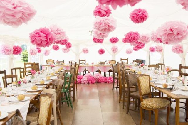 Pink and blush paper balls and blooms attached to the wall and over the reception is a cool idea