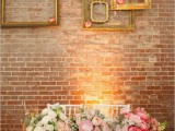 gold frames attached to the wall with pink blooms is a refined and chic decor idea for most of weddings