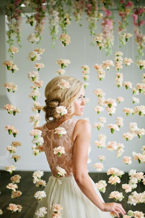 threads with carnations hanging down make up a cool wedding backdrop with a strong romantic feel