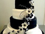 a large wedding cake with black and white tiers and sugar flowers in blakc and white is a sophisticated wedding cake