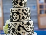a white wedding cake decorated with elegant and chic black floral patterns all over looks very pretty