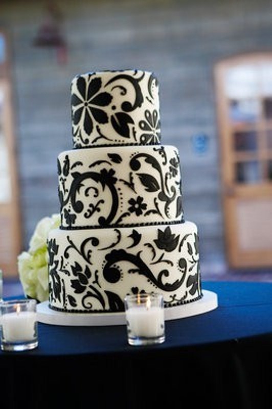 A white wedding cake decorated with elegant and chic black floral patterns all over looks very pretty