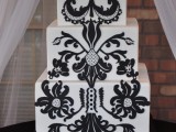 a white wedding cake decorated with unusual black patterns will fit a folksy wedding