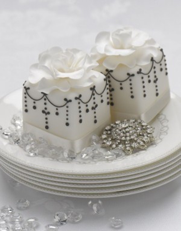 White square wedding mini cakes with black patterns and white sugar blooms on top