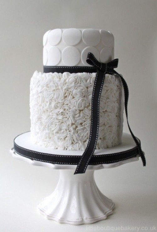 a white wedding cake with a textural and a polka dot tier plus black ribbons is a fresh take on classics
