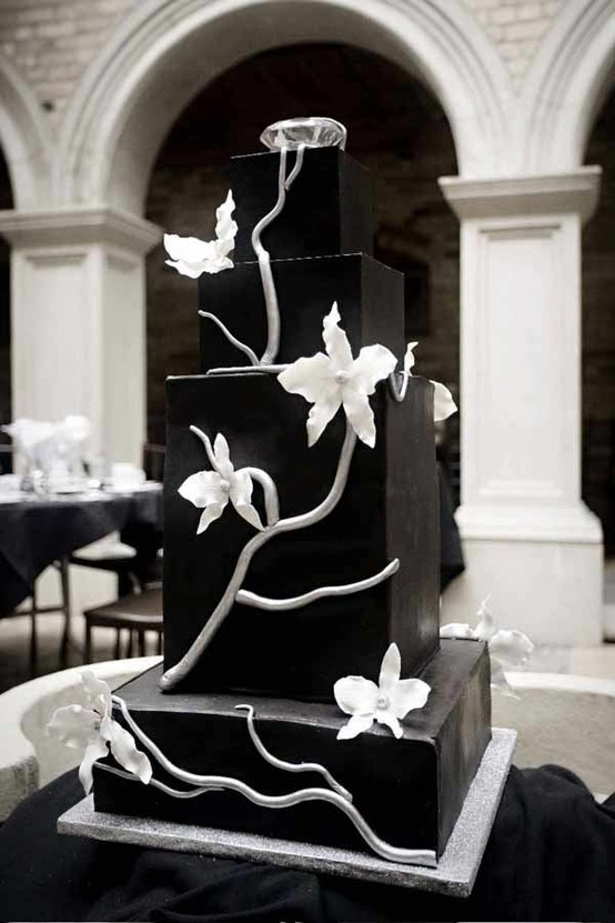 A black square wedding cake decorated with white sugar branches and flowers is a masterpiece