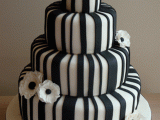 a fully striped black and white wedding cake topped with anemones is a bold and eye-catchy idea