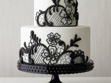 a white wedding cake decorated with blakc lace is a veyr refined idea