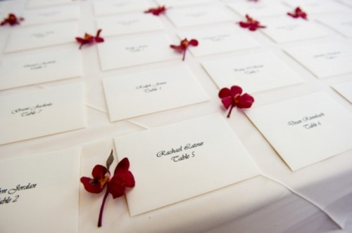 escort cards accented with deep red blooms are amazing for a fall or winter wedding