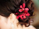 deep red blooms accenting your wedding hair is a chic and bold idea to go for