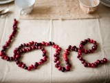 a LOVE garland of cranberries is a cute and cozy idea for a fall or winter wedding