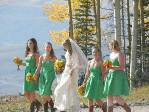 strapless apple green over the knee bridesmaid dresses with draping and cowboy boots are a very cool and bold idea for a fall wedding