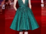 an emerald green knee A-line bridesmaid dress with no sleeves, a deep V-neckline and embellishments all over the dress is a jaw-dropping idea