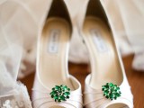 white peep toe wedding shoes with emerald brooches attached for a lovely and bright touch of color are amazing for a wedding with a green color scheme