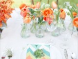 a bright spring wedding tablescape with orange tulips, colorful ikat napkins and succulents is a bold and cool idea
